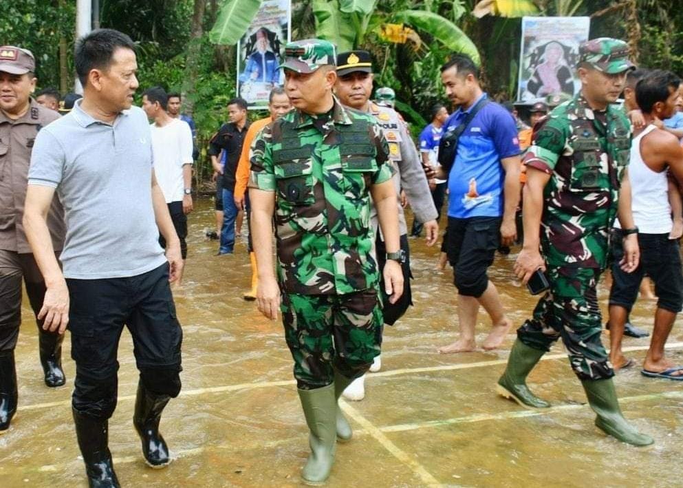 PJ Bupati Kampar bersama rombongan tampak berjalan menuju lokasi yang terdampak banjir.