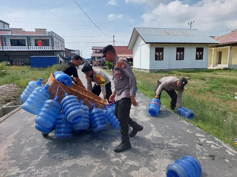 Polisi menjumpai warga yang sedang bersusah payah mengumpulkan galon air yang terjatuh dijalan.